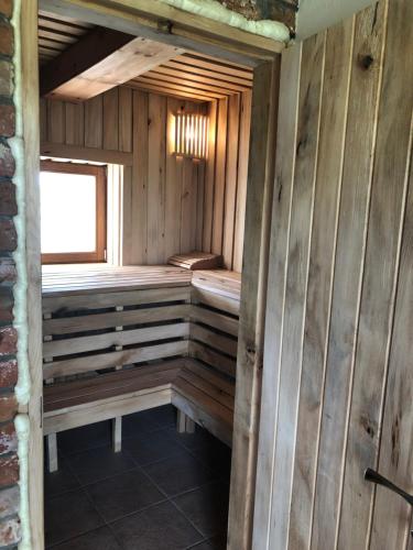 a sauna with wooden walls and a window at ALANTOS ŽIRGAI Holiday Villas sauna or hottube additional price in Alanta