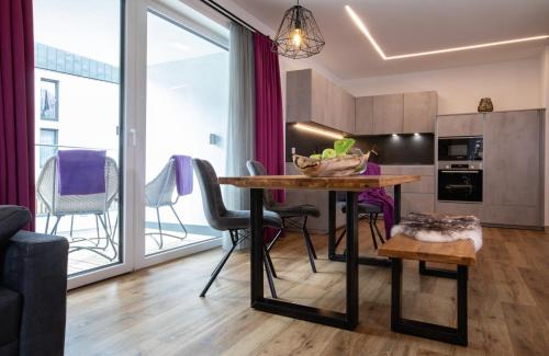 a kitchen and living room with a table and chairs at ImPuls | aparts in Schladming