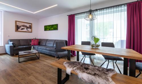 a living room with a table and a couch at ImPuls | aparts in Schladming