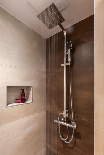 a shower with a shower head in a bathroom at ImPuls | aparts in Schladming