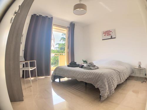 una camera da letto con un letto e una grande finestra di CANNES SERGENT GAZAN a Cannes