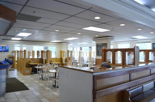 a gym with tables and chairs and a bar at Valley Hotel & 24/7 Open Cafe in Palmer