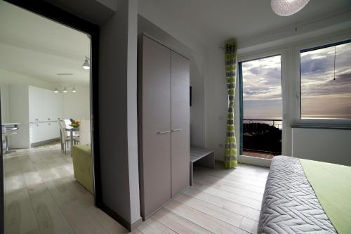 a bedroom with a door to a room with a balcony at Villa Bellatrix in Massa Lubrense
