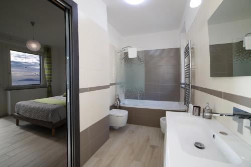 a bathroom with a sink and a toilet and a bed at Villa Bellatrix in Massa Lubrense