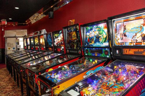 a row of pinball machines in a room at Ramada by Wyndham Edmonton Yellowhead NW in Edmonton