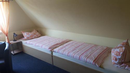 Cama pequeña en habitación con en Hausnordlicht Dachspitze 2, en Dornumergrode