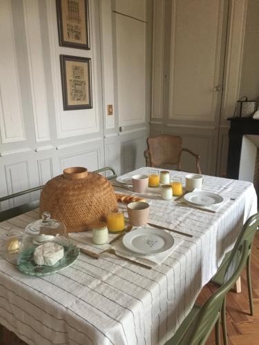 - une table blanche avec des assiettes et des bougies dans l'établissement Suite&Caux 1, à Cany-Barville