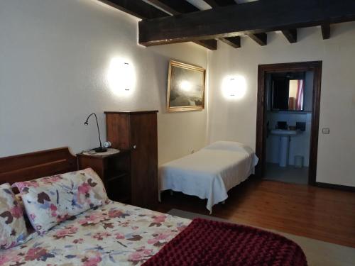 a bedroom with a bed and a room with a sink at Agroturismo Iturbe in Axpe de Busturia