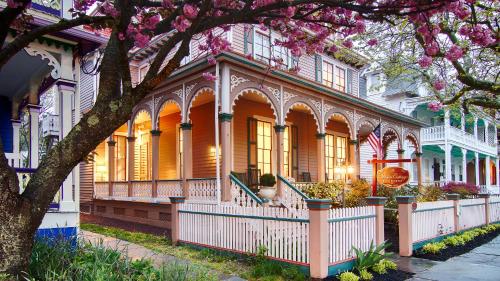 a house with a flowering tree in front of it at The Mason Cottage Downtown in Cape May