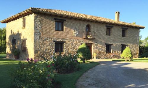 a large stone house with a driveway in front of it at Finca el Consul in Logroño