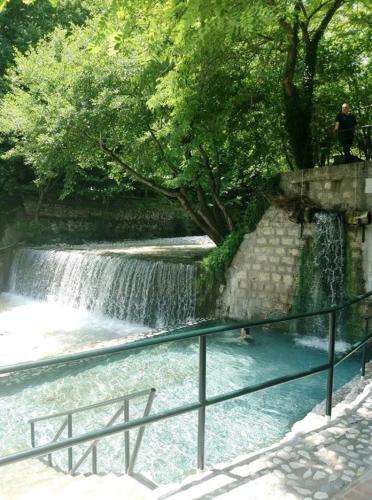 a waterfall with a person swimming in a river at Alexandros in Aridaia