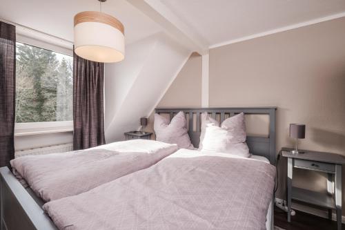 1 Schlafzimmer mit 2 weißen Betten und einem Fenster in der Unterkunft Schierke Ferienwohnung Hirschrudel in Schierke