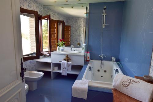 a bathroom with a tub and a sink and a toilet at Finca el Consul in Logroño