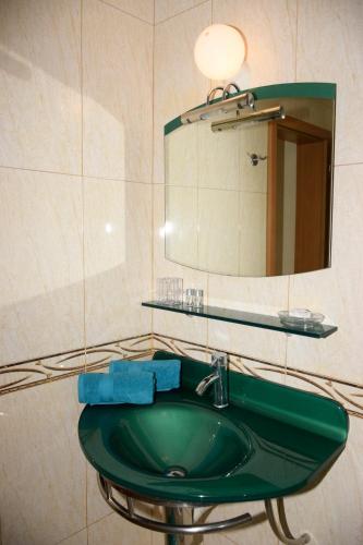 a bathroom with a green sink and a mirror at Rusalka Apart-Residence in Obzor
