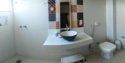 a bathroom with a bowl sink and a toilet at Orla Graciosa in Palmas
