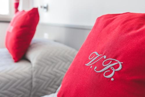 a red pillow sitting on top of a bed with a red at Villa Bellatrix in Massa Lubrense