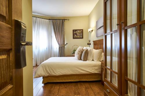 Una habitación de hotel con una cama y una ventana. en Casona De Torres, en Mondéjar