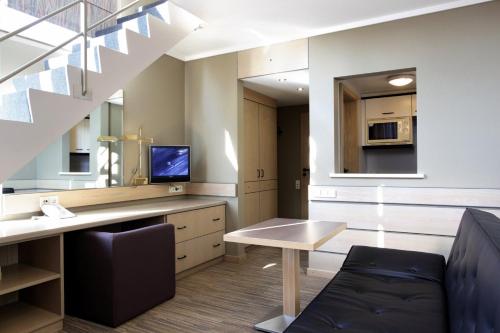 a living room with a desk and a couch at Hotel Olivier in Luxembourg