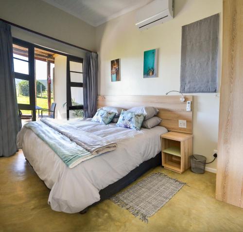 a bedroom with a large bed and a table at Addo Park Vista in Addo