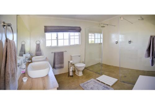 a bathroom with a toilet and a glass shower at Addo Park Vista in Addo