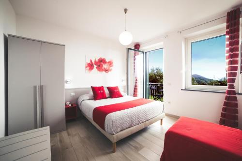 a bedroom with a bed with red pillows and a window at Villa Bellatrix in Massa Lubrense