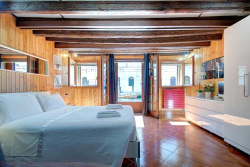a bedroom with a large bed and some windows at Canal-Door in Venice
