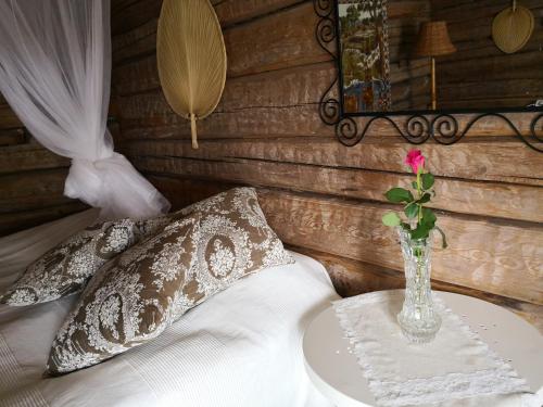 un vaso con un fiore su un tavolo in una camera da letto di Eräjärven Eerola aittahuone (summer room) a Eräjärvi
