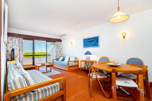 een woonkamer met een tafel en een bank bij WHome | Vilamoura Sunny Apartment in Quarteira