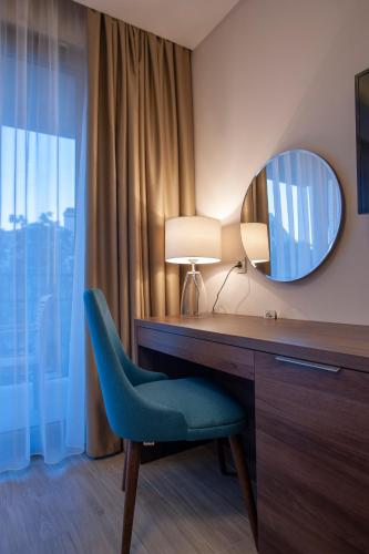 a room with a desk and a chair and a mirror at Hotel Twelve by Aycon in Budva