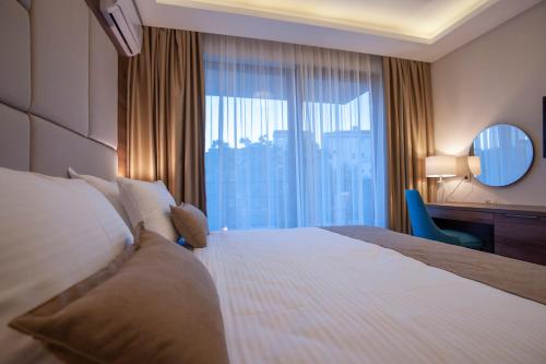 a hotel room with a large bed and a window at Hotel Twelve by Aycon in Budva