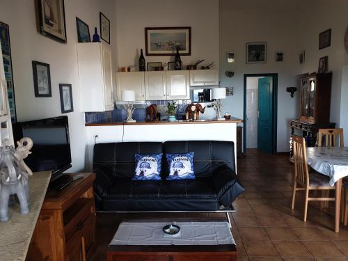 a living room with a black couch and a table at casabellavista in Bonifacio