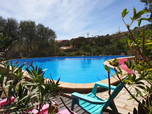 a blue swimming pool with a chair next to it at casabellavista in Bonifacio