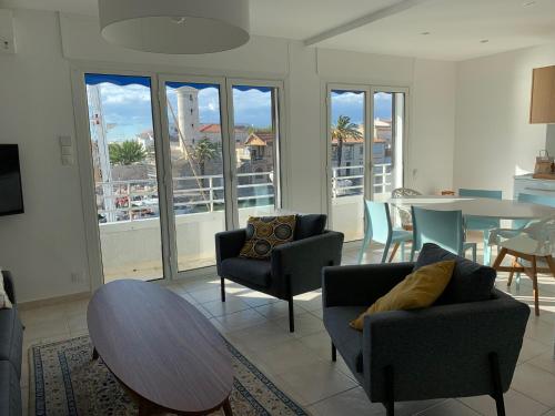 Una sala de estar con mesa y sillas y un comedor. en L'Imperial, en Le Grau-du-Roi