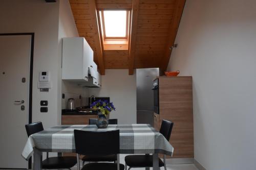 a kitchen and dining room with a table and chairs at Appartamenti al Canton in Colà di Lazise