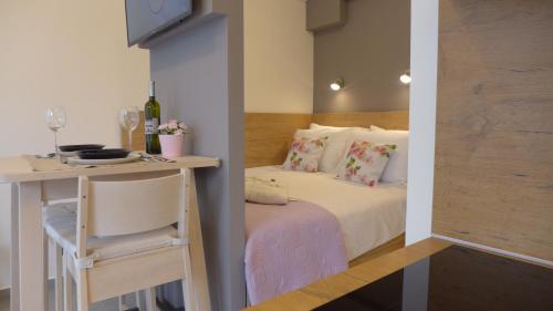 a small bedroom with a bed and a table with a chair at Studio Claudia in Opatija