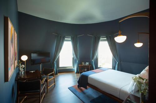 a bedroom with a bed and a desk and a television at The Vintage Hotel & Spa Lisbon in Lisbon