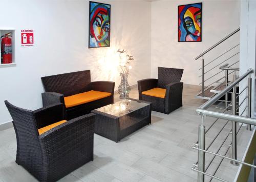 a lobby with two chairs and a table and paintings at Hotel San José in San José