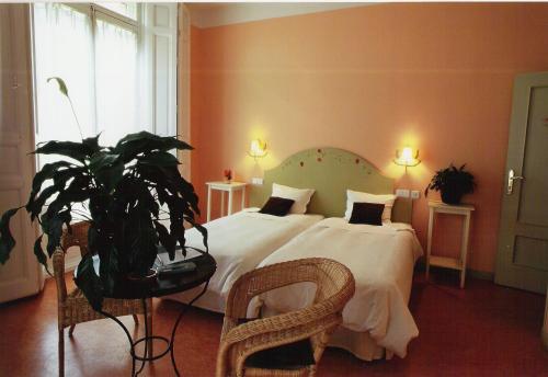 a bedroom with a large bed and a potted plant at Hostal Fornos in Segovia