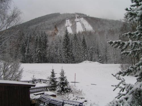 a snow covered mountain with a ski lift on it at Pension U Krtka - přímo u sjezdovky in Harrachov