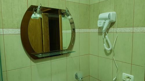 a bathroom with a mirror and a hair dryer at Olive Tree Apartment in Sarandë