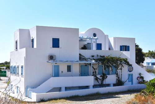 a white building with blue doors and windows at Adelphi Apartments in Perissa