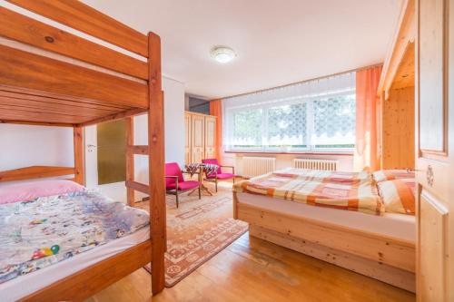 a bedroom with two bunk beds and a living room at Pokoje Olech in Wrzosowo