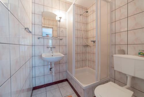 a bathroom with a sink and a toilet and a shower at Pokoje Olech in Wrzosowo