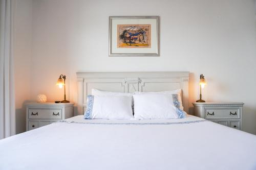 パレオ・ティフリキにあるIsminis Houseのベッドルーム1室(白いベッド1台、ナイトスタンド2台付)