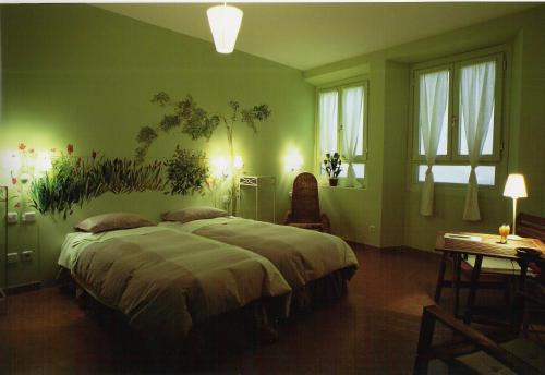 Un dormitorio verde con una cama grande y una mesa. en Hostal Fornos, en Segovia