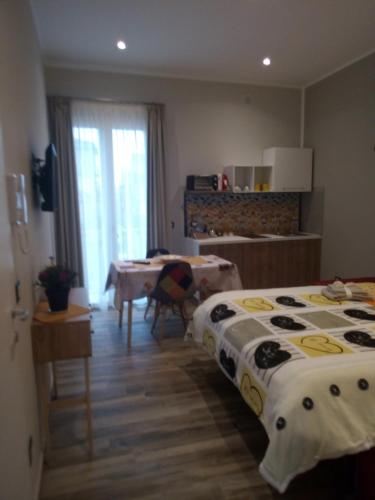 a room with two beds and a table and a kitchen at Case Vacanza Le Casette in Santo Stefano di Camastra