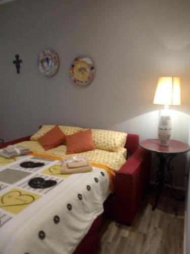 a bedroom with a bed and a table with a lamp at Case Vacanza Le Casette in Santo Stefano di Camastra