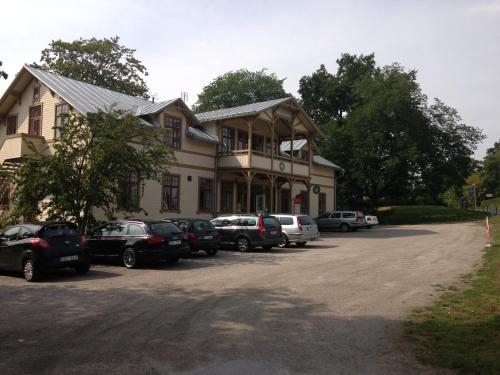 a large house with cars parked in a parking lot at Ronneby Brunnspark Vandrarhem och B&B in Ronneby