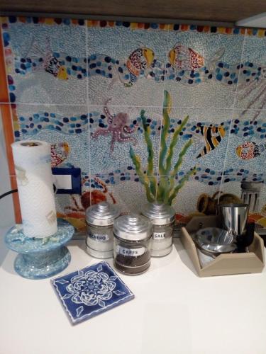 a counter with a shelf with a vase and other items at Case Vacanza Le Casette in Santo Stefano di Camastra