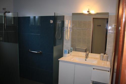 a bathroom with a sink and a shower with a mirror at Vila Calaça in Funchal